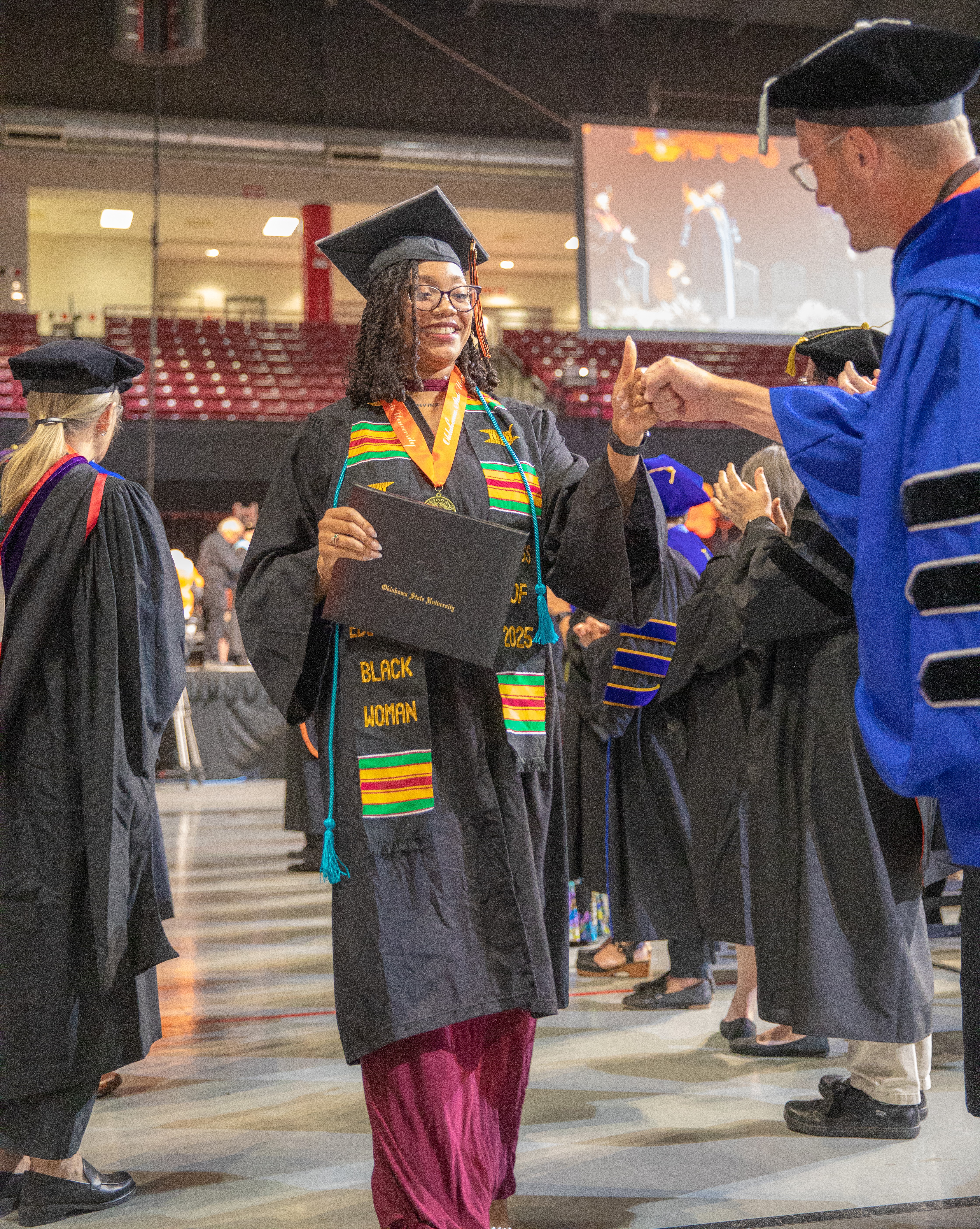 Graduate fist bumps professor