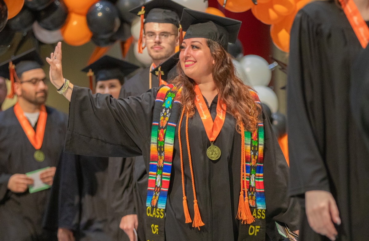 Graduates stand during ceremony