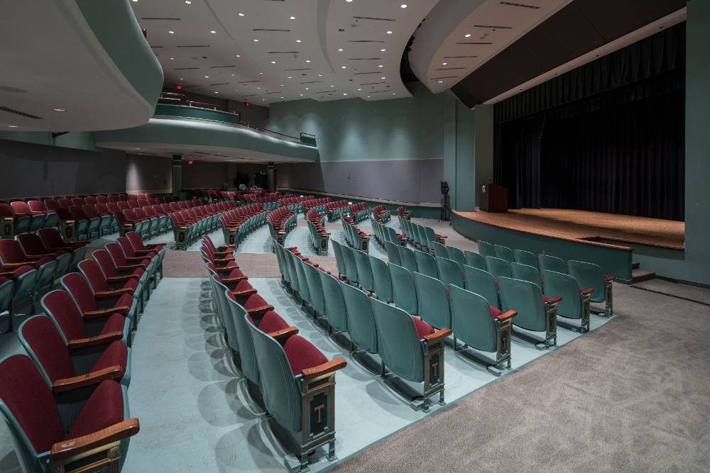 Auditorium with ramp seating, staging, and a presentation podium Auditorium with ramp seating, staging, and a presentation podium